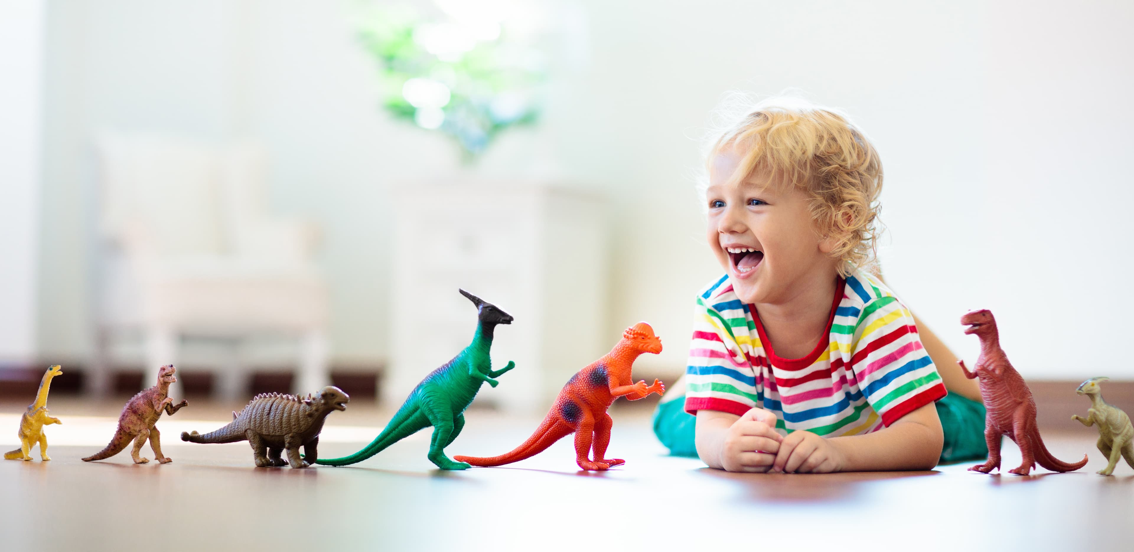 Two toddlers playing with a toy train set.