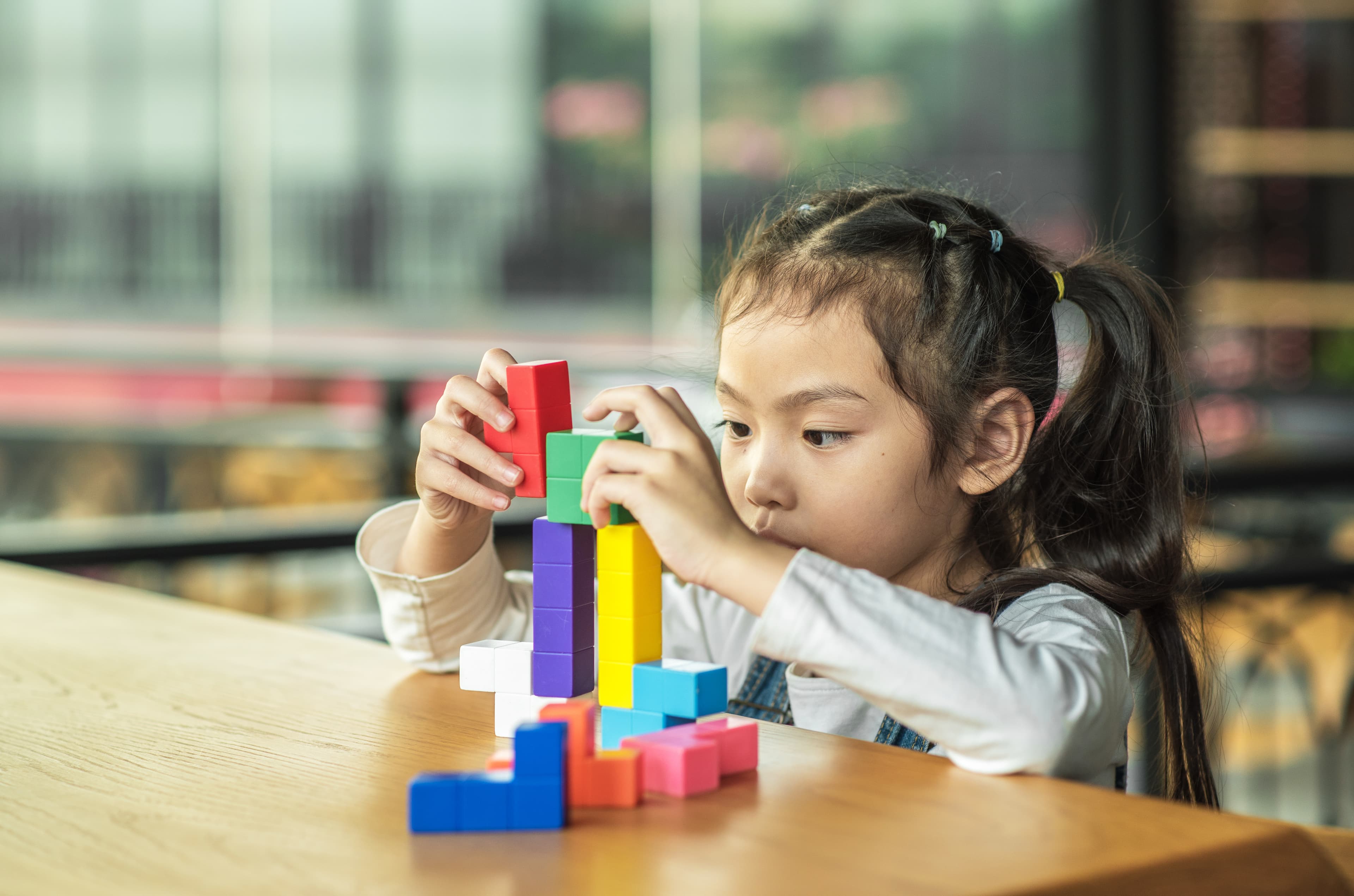 A child playing with building blocks on a table