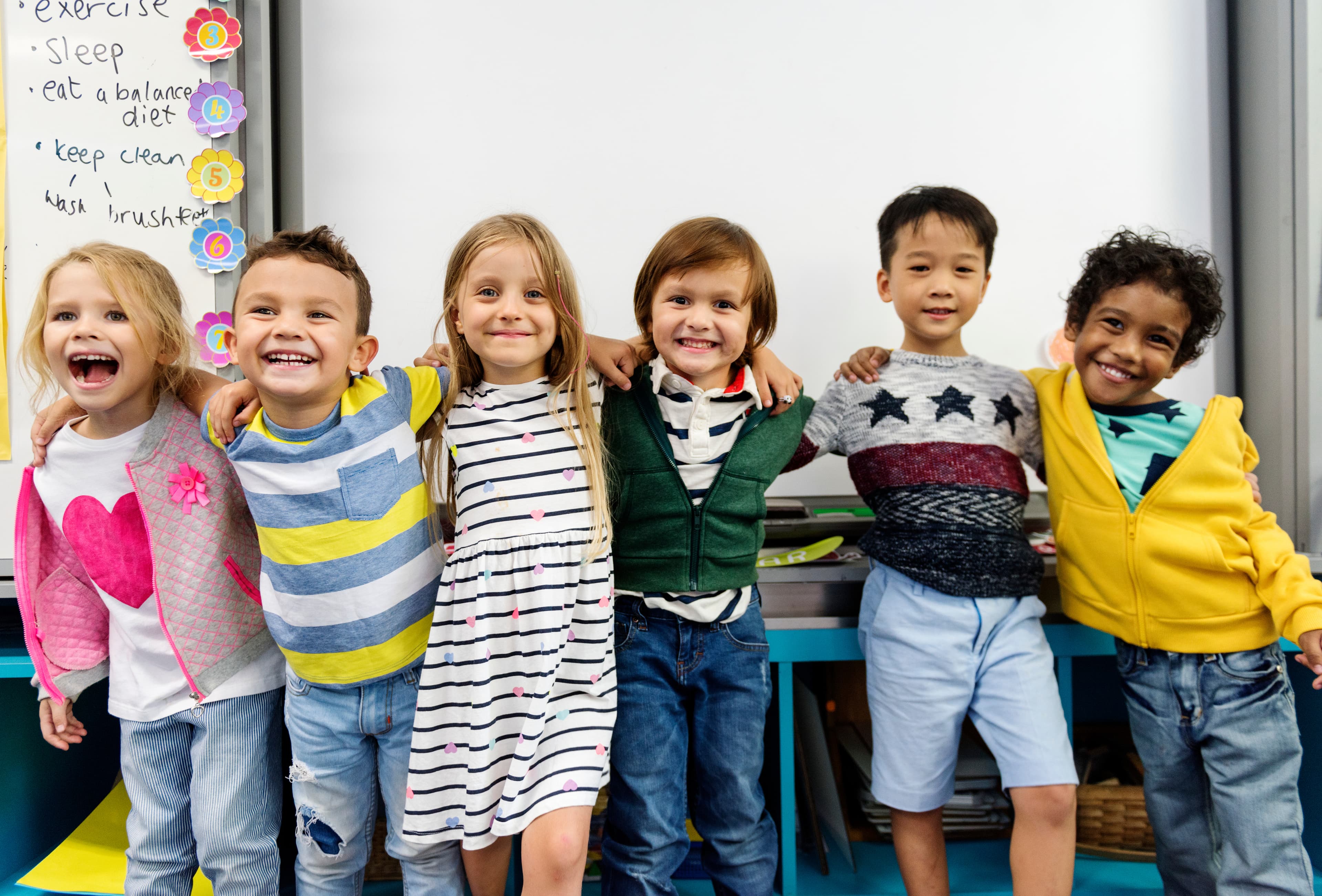 Six children smiling in a classroom