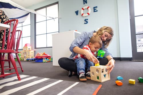 A woman and toddler playing with blocks