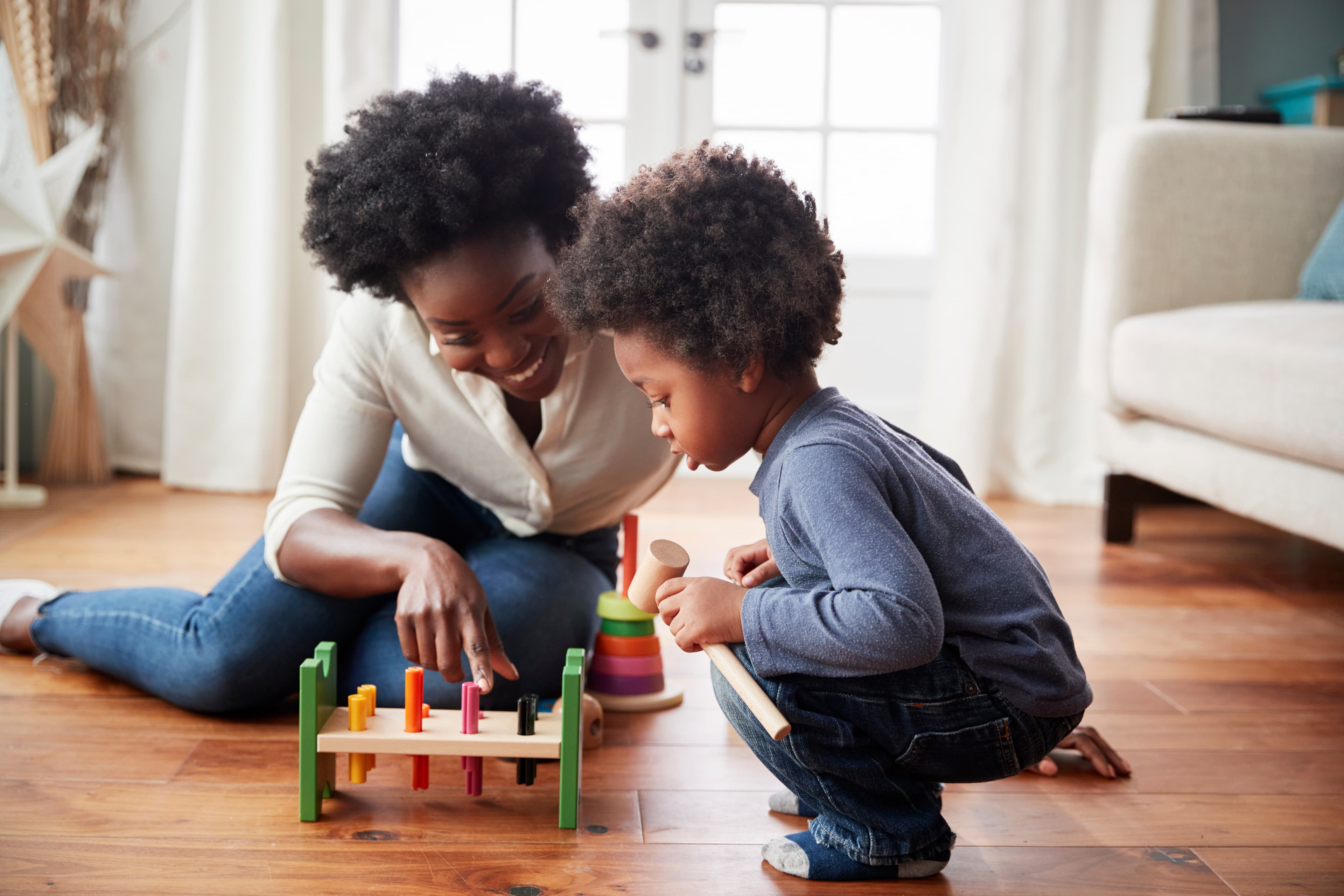 A woman and child playing a game on the floor